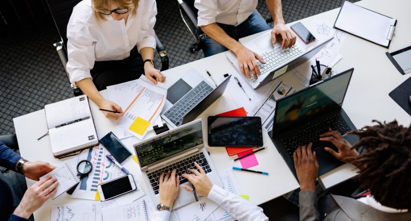 Uma equipe de funcionários se reúne no escritório de sua empresa.