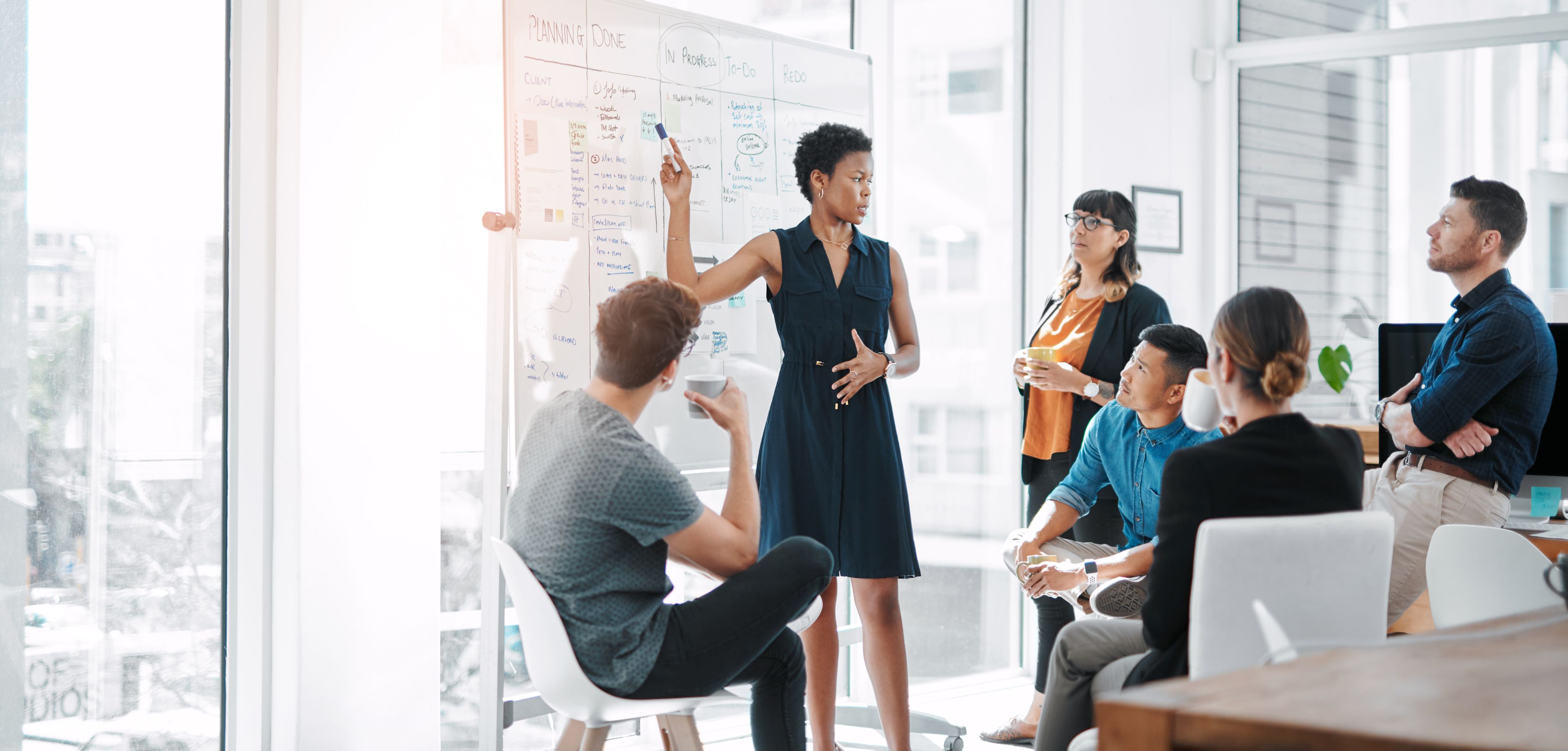 a imagem mostra pessoas reunidas em uma empresa fazendo um planejamento anual.