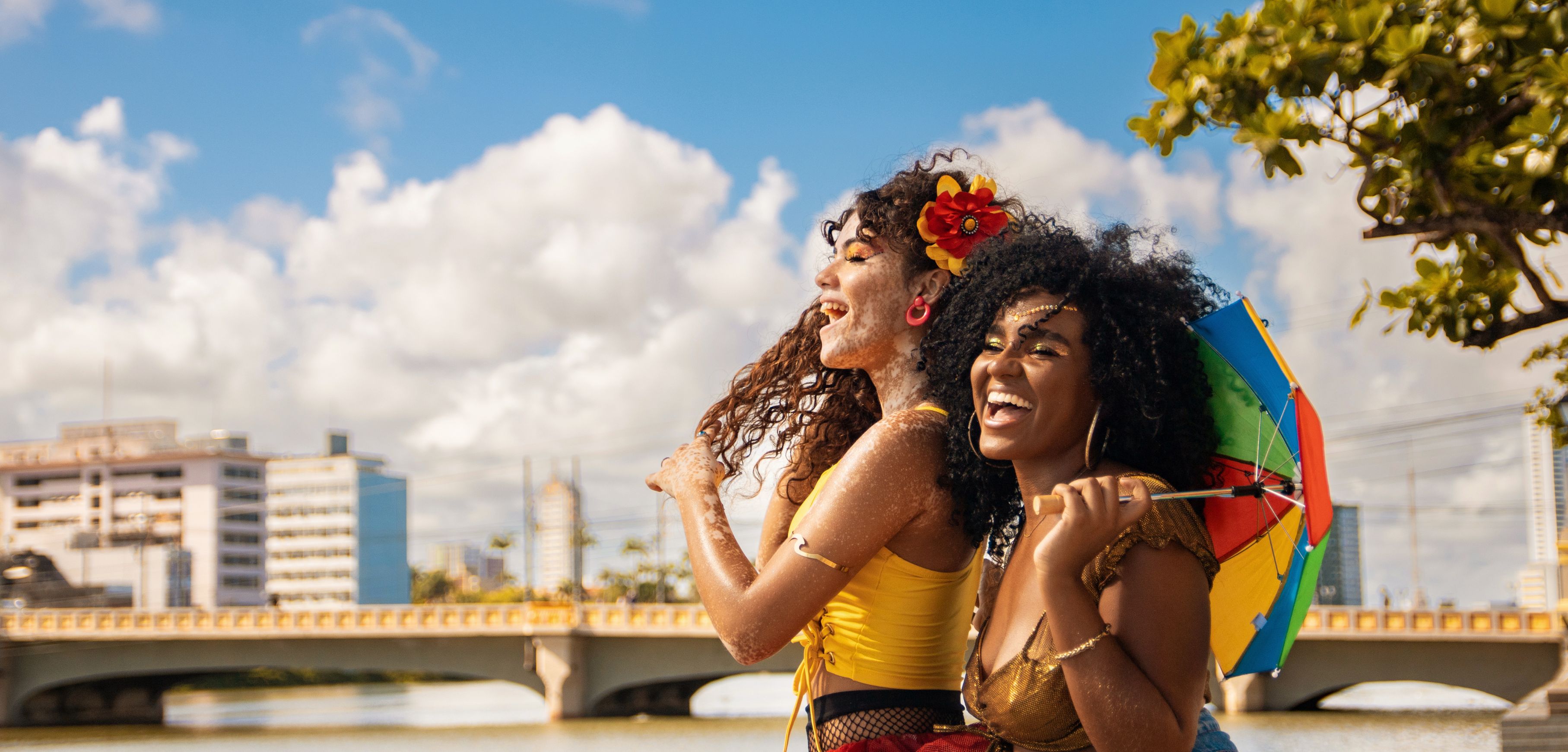 A imagem mostra duas mulheres aproveitando o Carnaval.