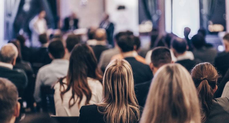 Grupo de pessoas participa de um evento corporativo.