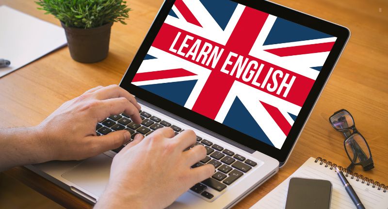 A imagem mostra um notebook com "learn english", que, em português, significa "aprenda inglês", na tela.