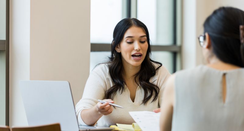 Profissional de recursos humanos dá orientações para uma colaboradora.