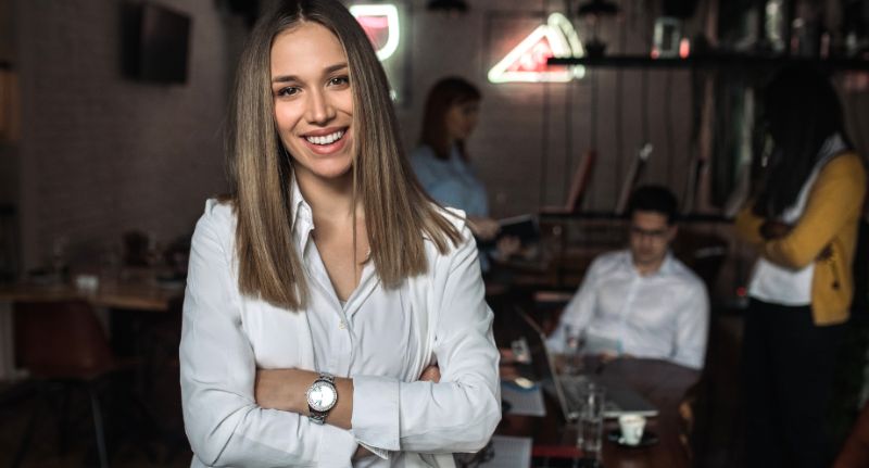 a imagem mostra uma mulher empreendedora com os braços cruzados.